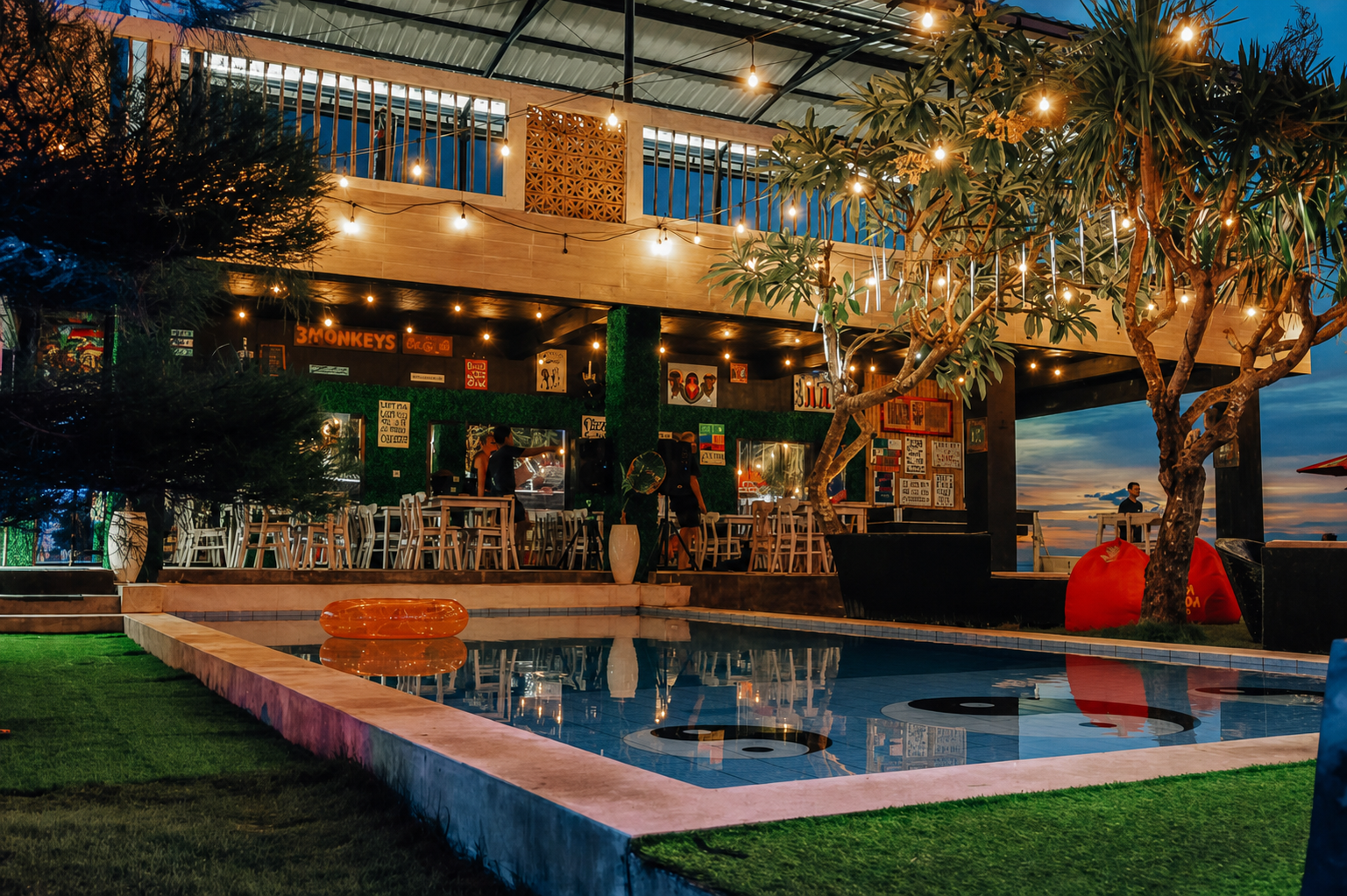 Illuminated evening pool and bar at 3 Monkeys Beach Club