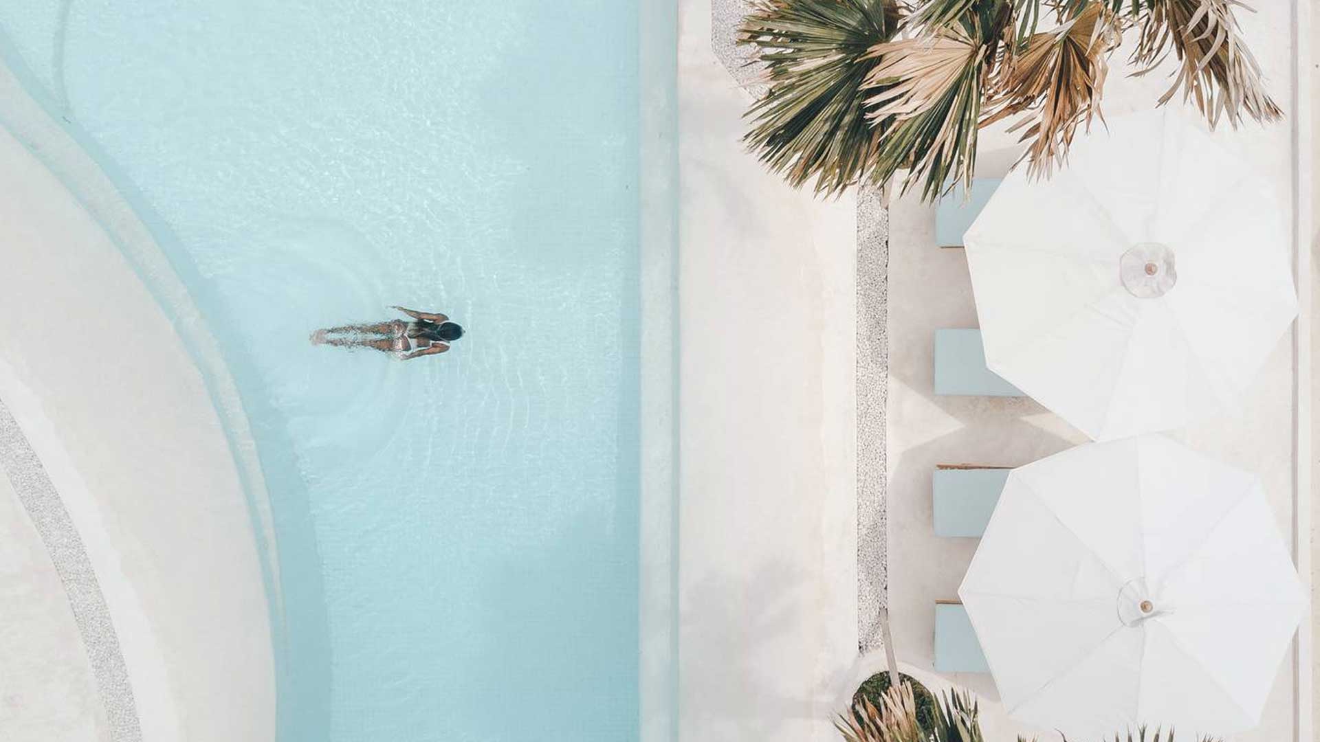 Curved pool and sun umbrellas at Alternative Beach