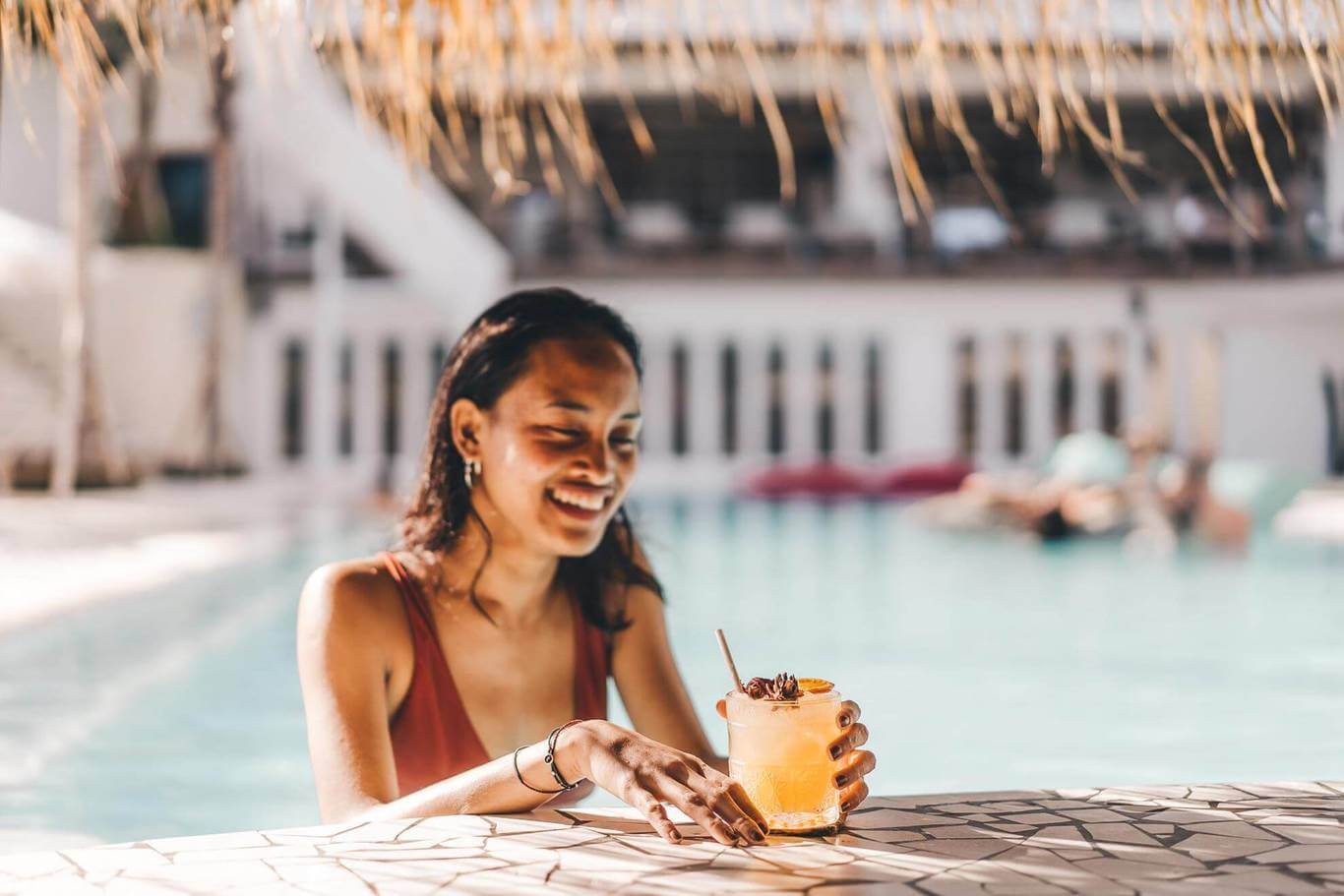 Guest enjoying a drink by the pool at Alternative Beach