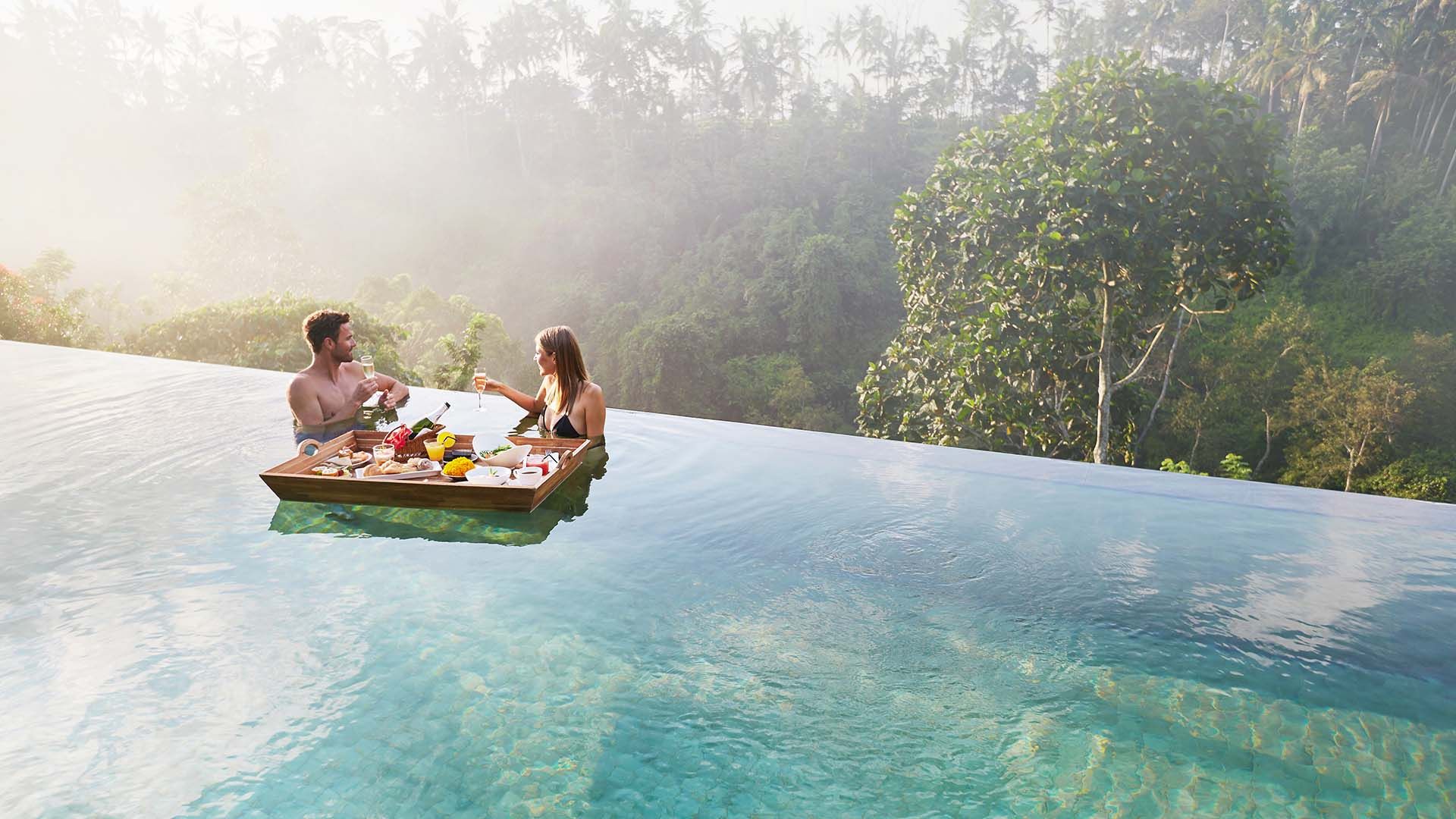 Pasangan menikmati sarapan terapung di kolam renang Awana Pool & Lounge