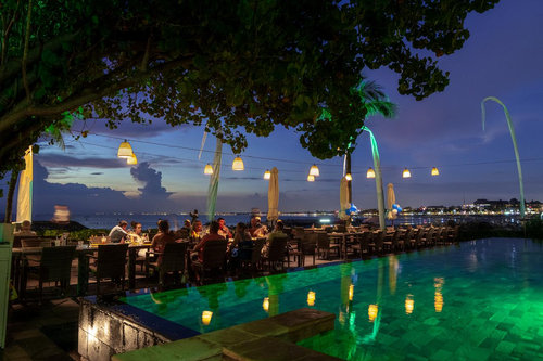 The Boardwalk Restaurant & Beach Club — 夕暮れのプールと海辺のテーブル
