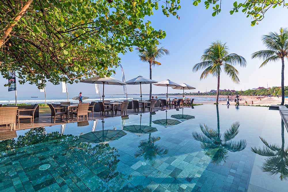Boardwalk pool overlooking the beach and palm trees