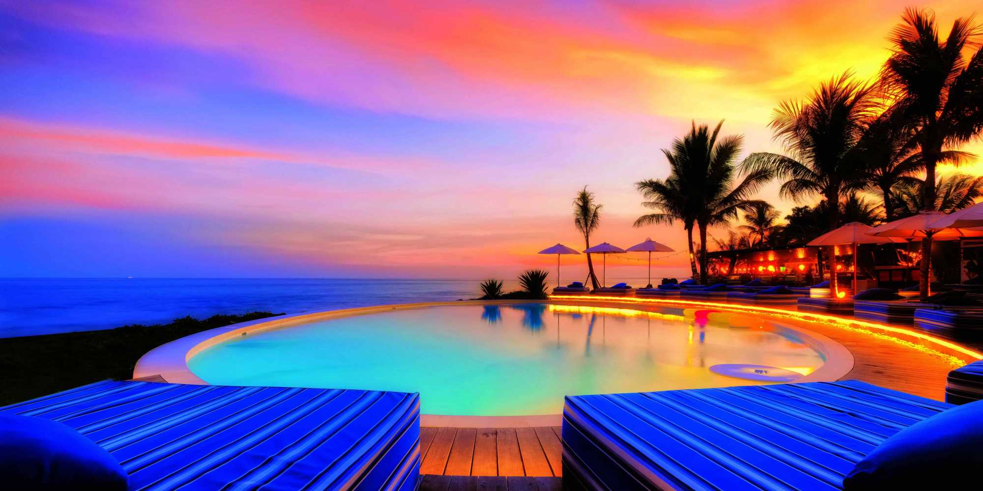 Komune Beach Club Keramas — Pool beneath a colourful sky