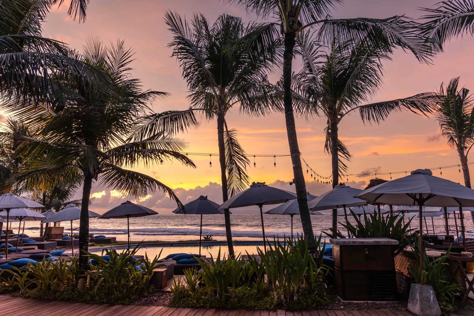 Komune Beach Club Keramas — Ocean and sky behind the palms