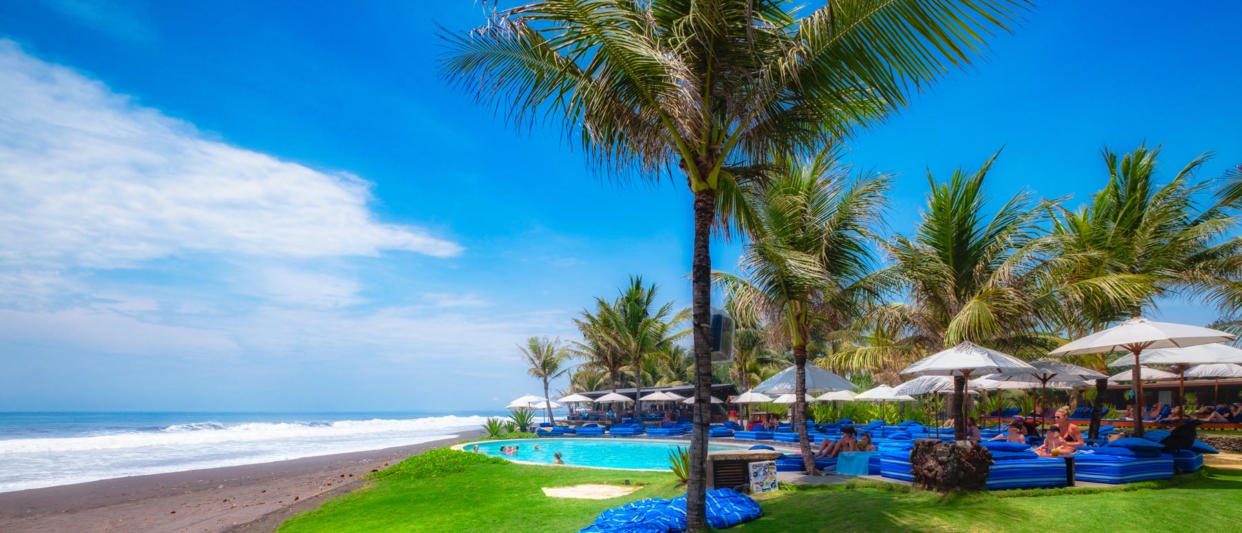 Komune Beach Club Keramas — Seaside lawn and palms