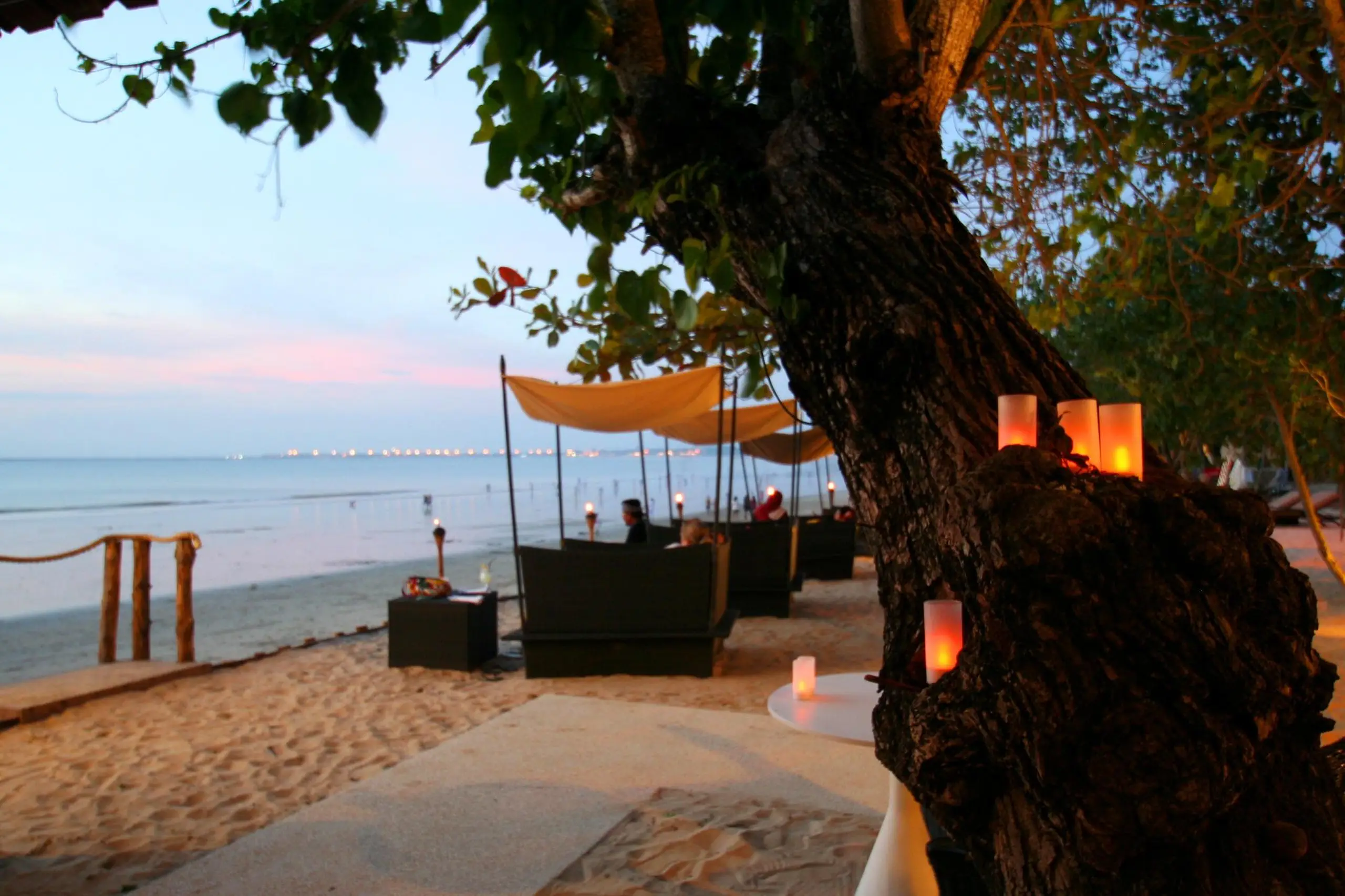 Beach cabanas at Kupu Kupu Jimbaran Beach Club at dusk