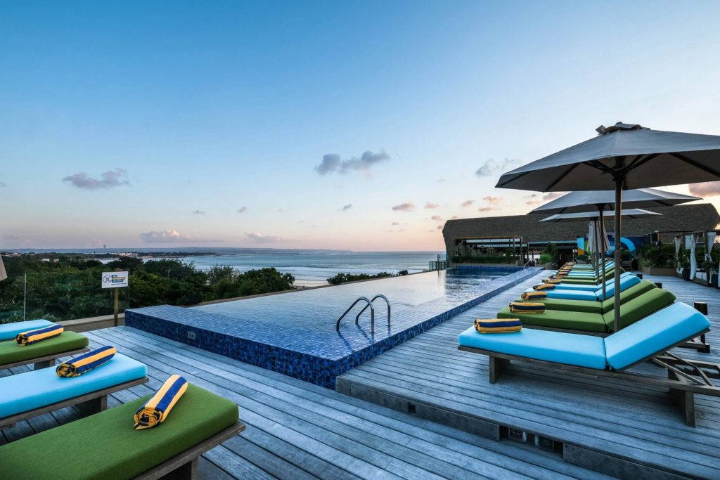 Kuta Social Club rooftop pool, daybeds and ocean-facing view