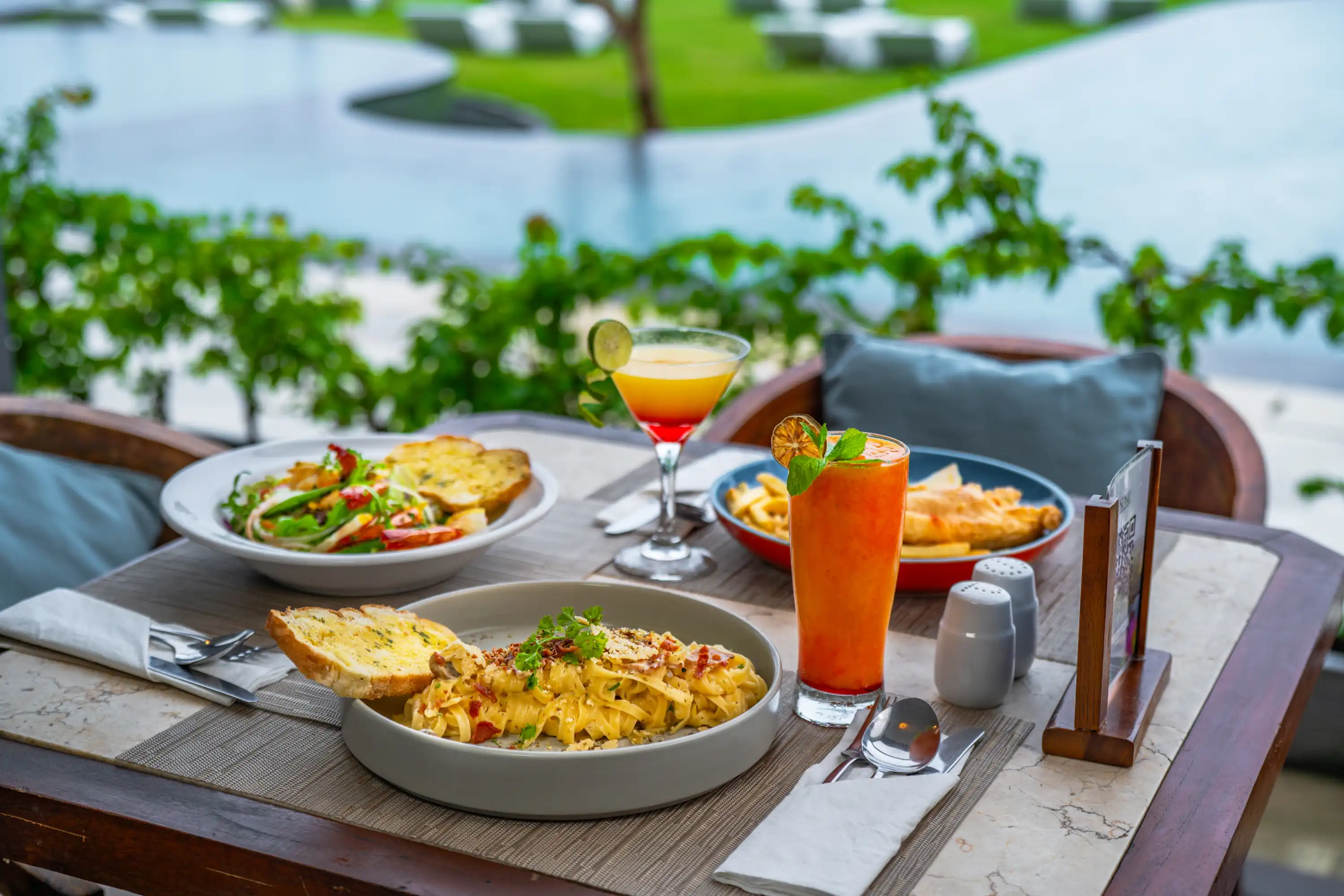 Dishes and cocktails arranged on a Sea Sky Lovina table
