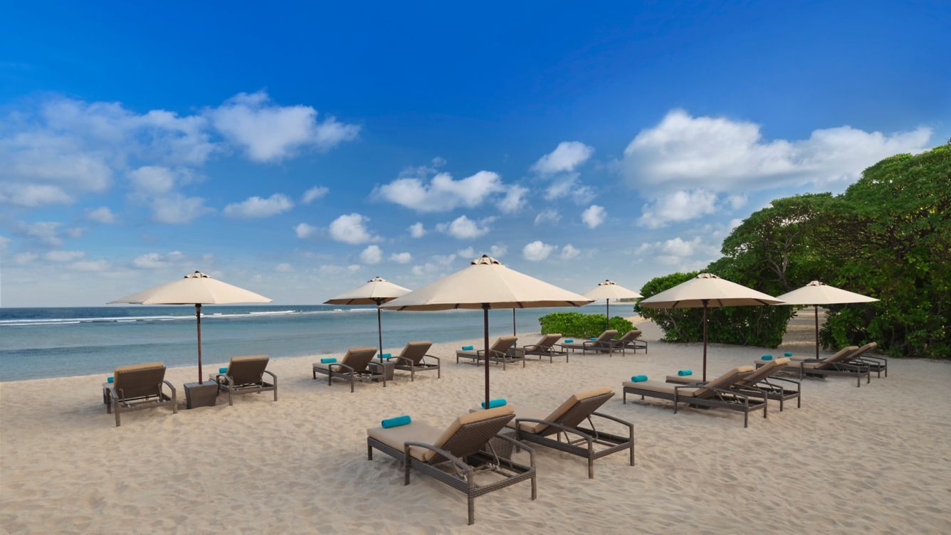 Kursi berjemur tepi pantai dan laut The Beach Club Nusa Dua