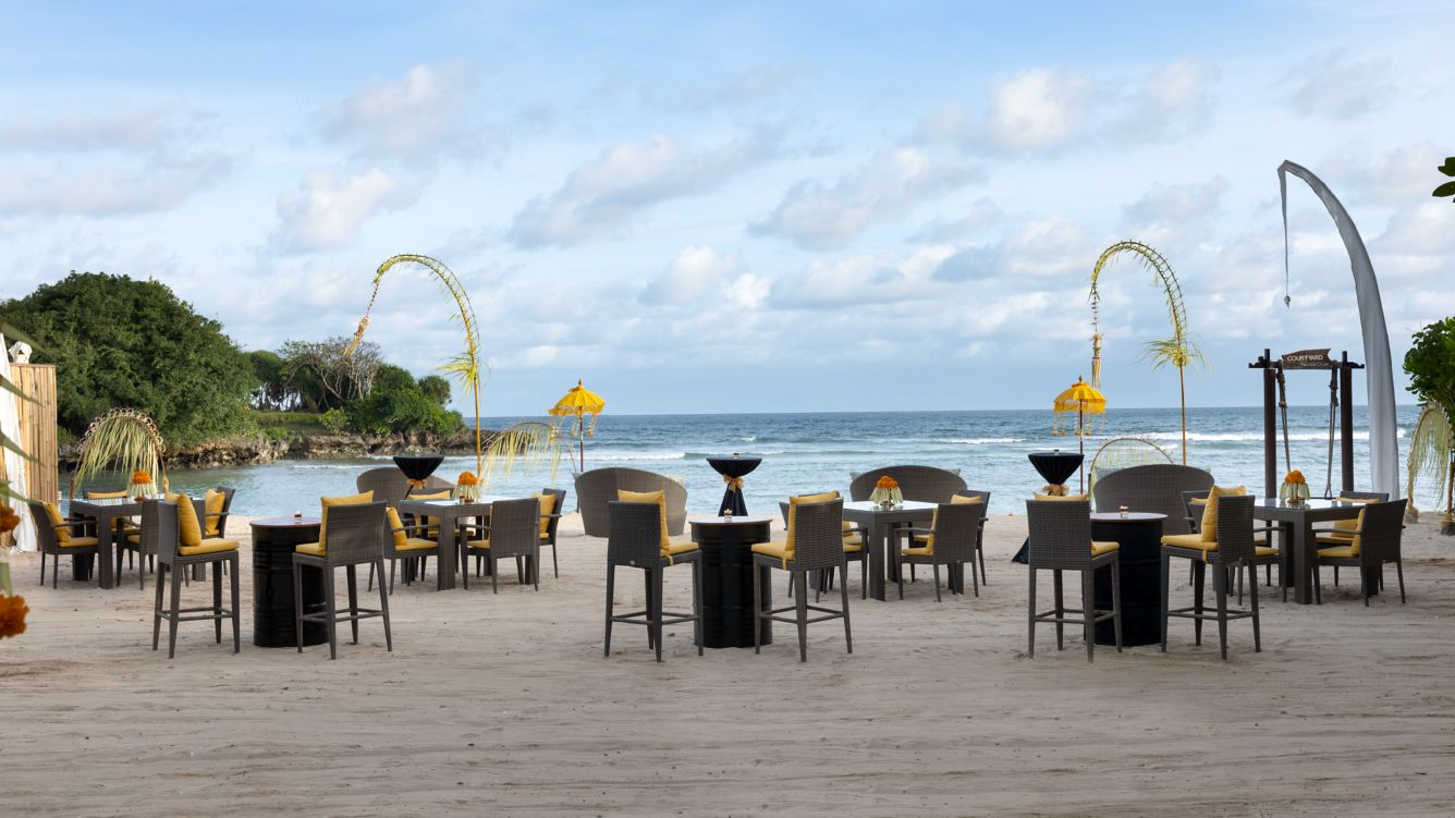 Meja makan malam tepi pantai di The Beach Club Nusa Dua