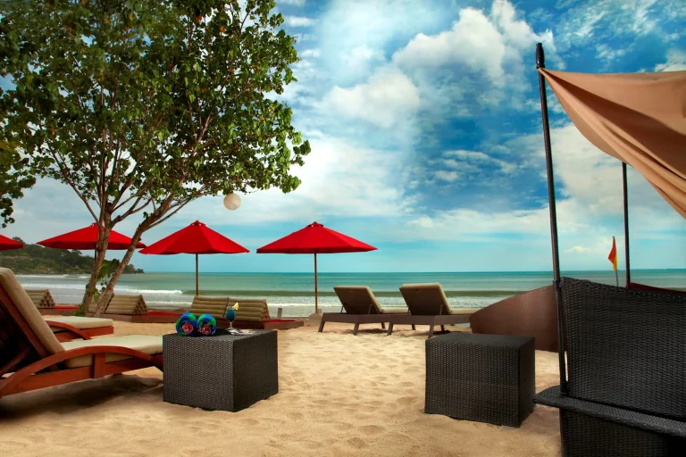 Kupu Kupu Jimbaran Beach Club dengan payung merah menghadap laut