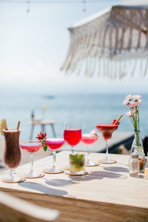 Table of colorful Penida Colada drinks with the sea behind