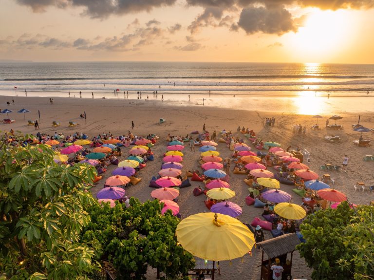 Colorful La Plancha Bali beanbags and umbrellas on Double Six Beach at sunset