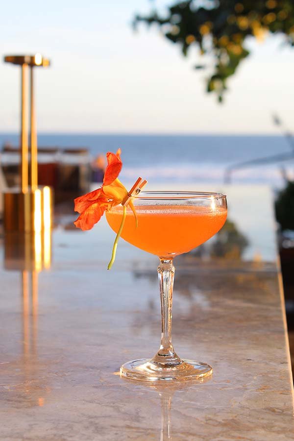 Cocktail dengan latar laut di Hippie Fish Pererenan