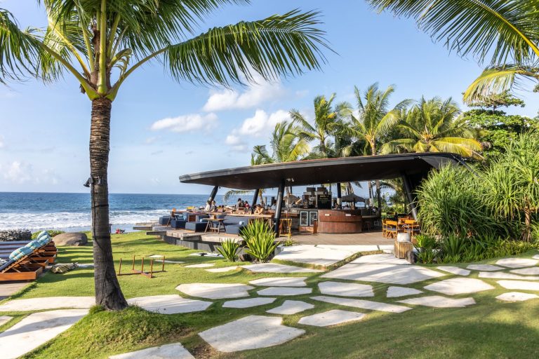 Beachfront lawn and beach club overview at Komune Beach Club Keramas