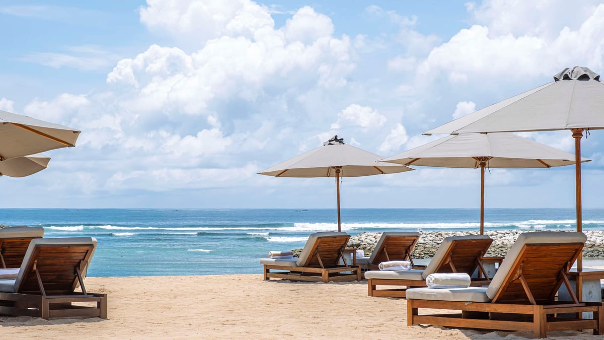Beach loungers with the ocean behind them.