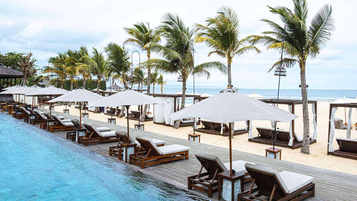 Daybeds and white umbrellas beside the pool.